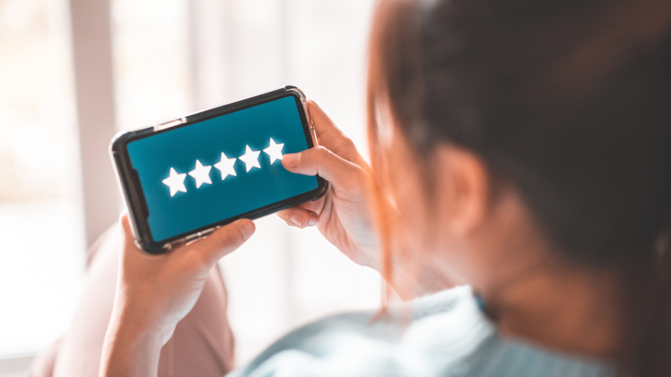 Woman Leaving 5 star review on her mobile phone